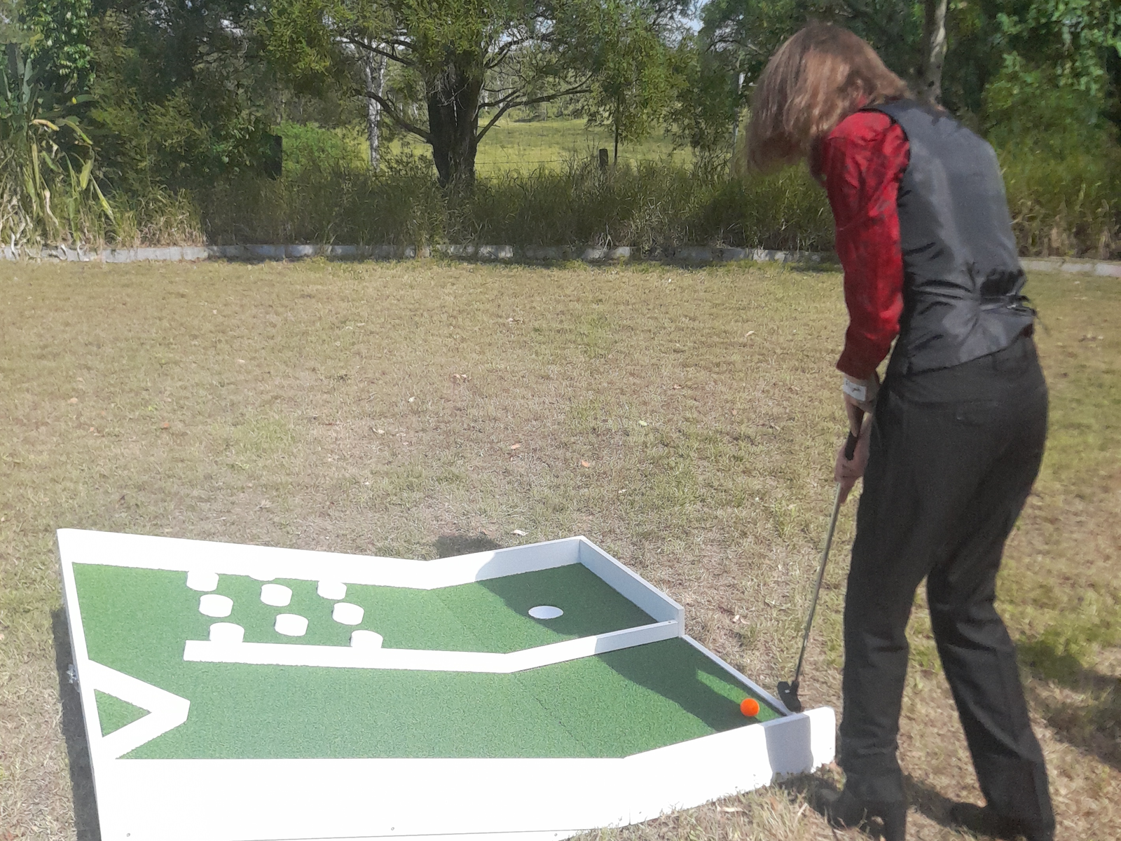 Wedding guest playing mini-golf.